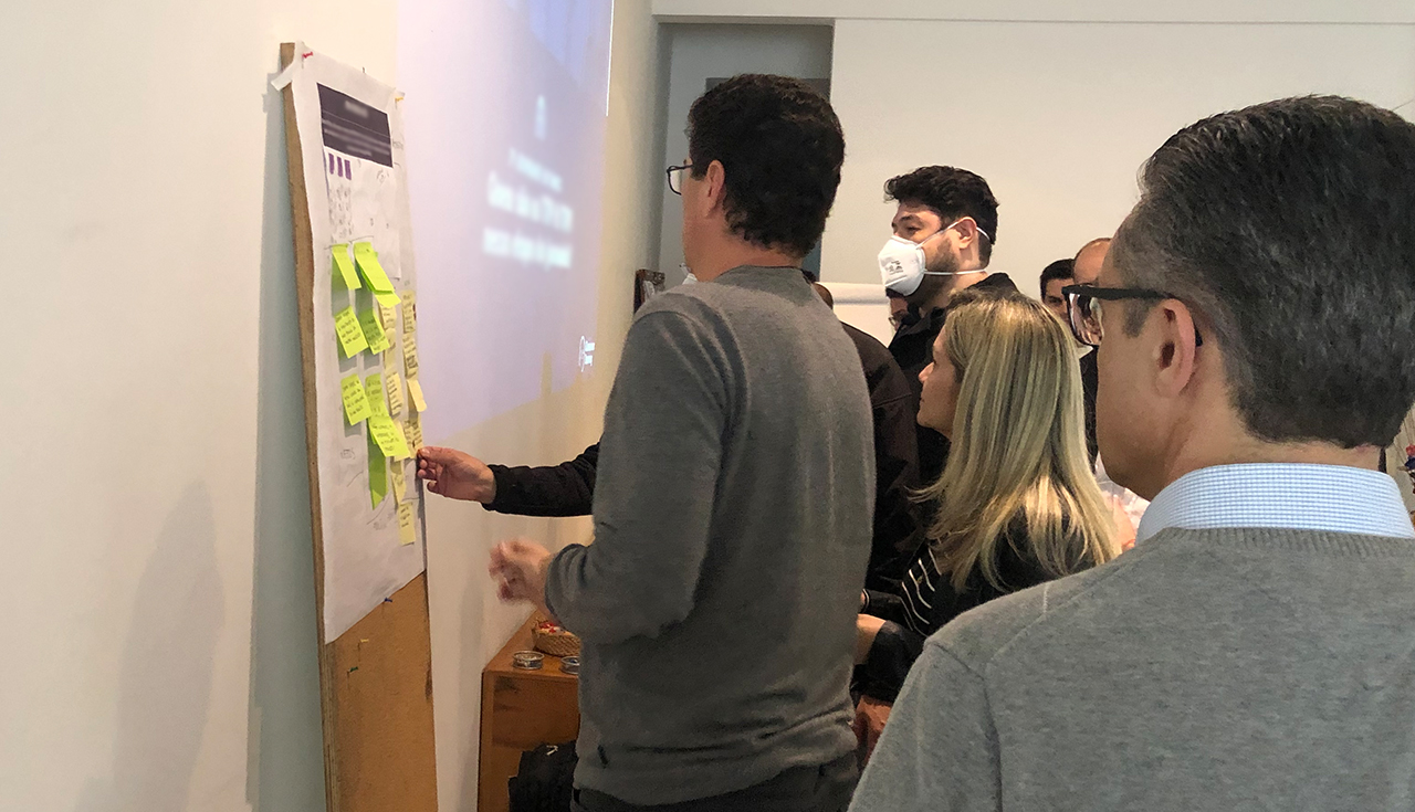 Participantes analisando oportunidades da jornada em painel colaborativo